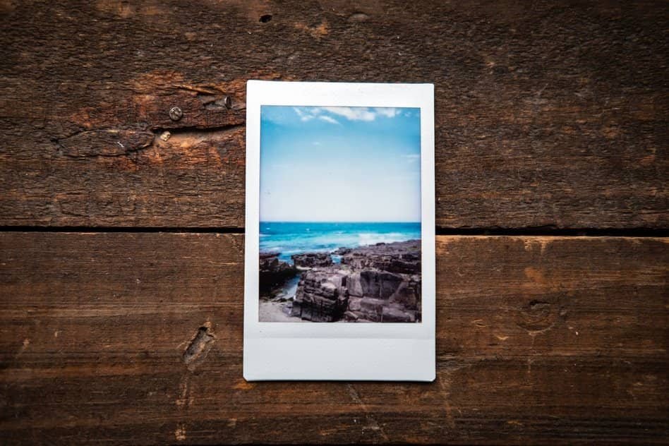 one printed photo with the blue sea on the wood background