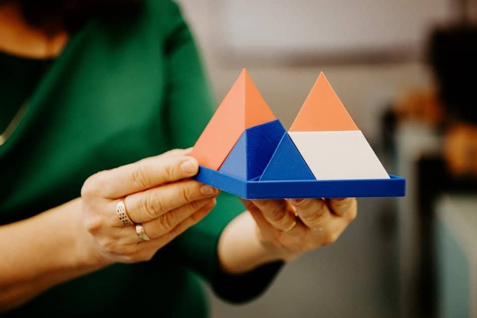 woman holding 3d printed triangle figures